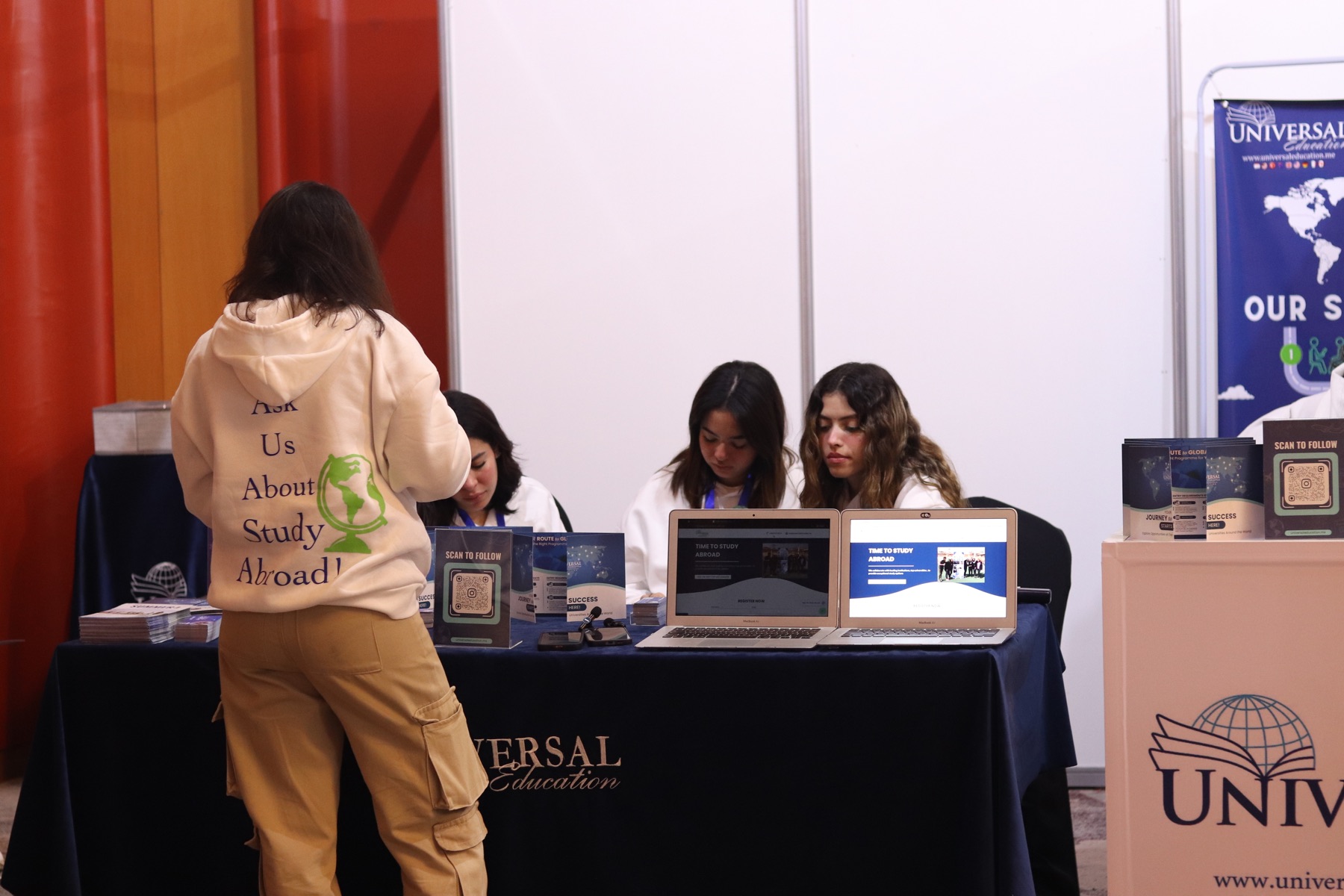 A family speaking with the Universal Education team at an education event
